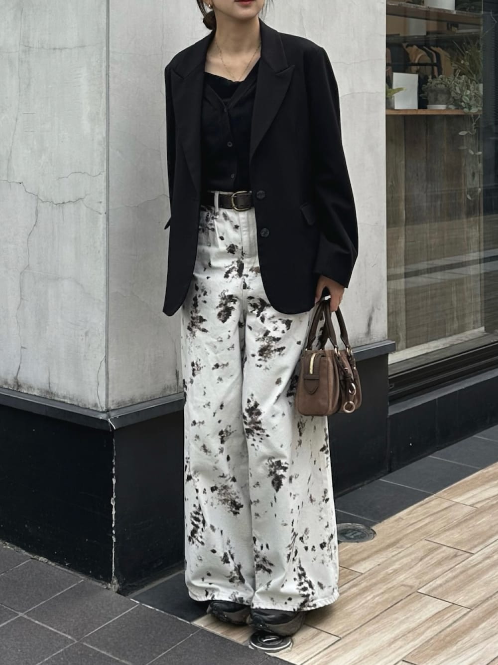 ホワイト系のデニムパンツ、ブラック系のテーラードジャケット、ブラウン系のトートバッグを着用したレディースの秋コーディネートの2枚目の写真