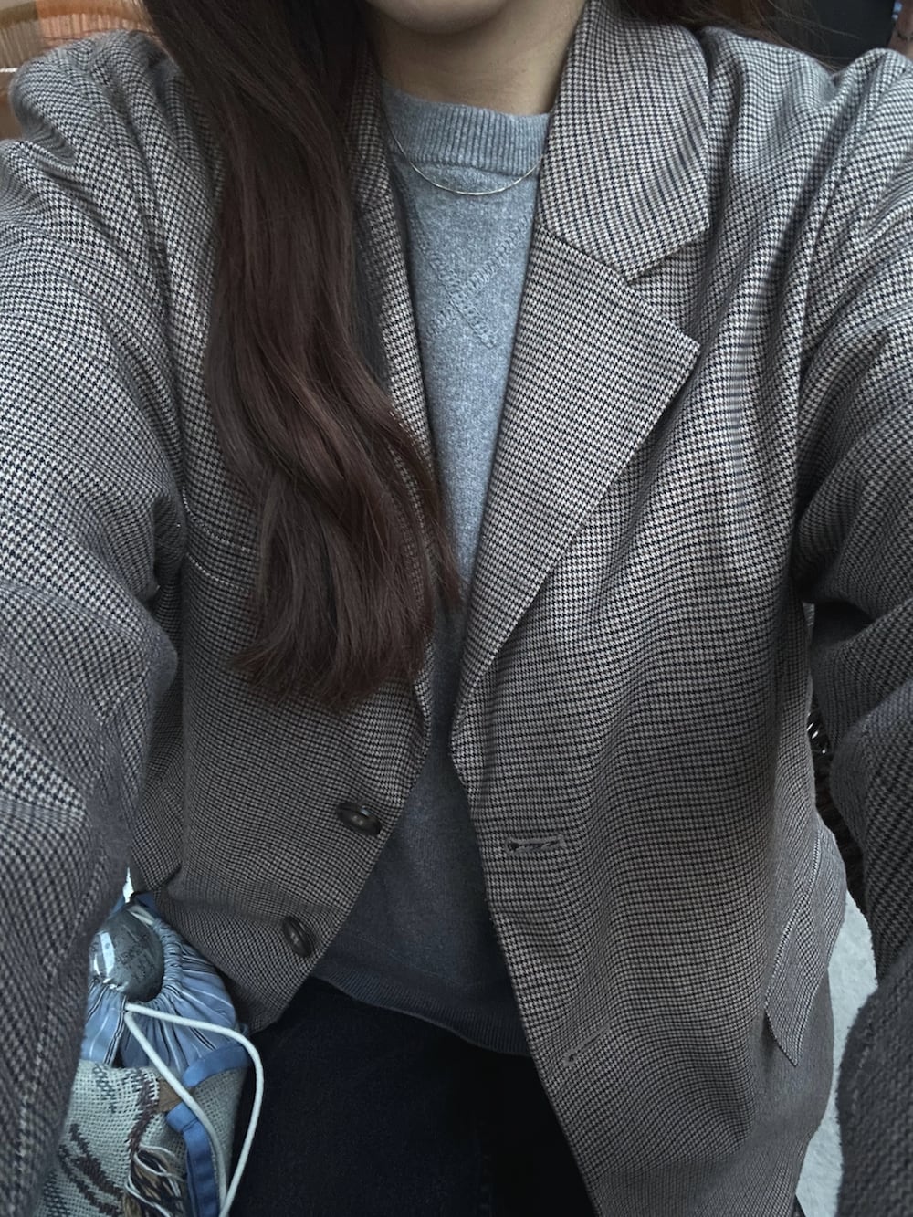 ブラウン系のテーラードジャケット、ブルー系のデニムパンツ、ベージュ系のサンダルを着用したレディースの春コーディネートの5枚目の写真