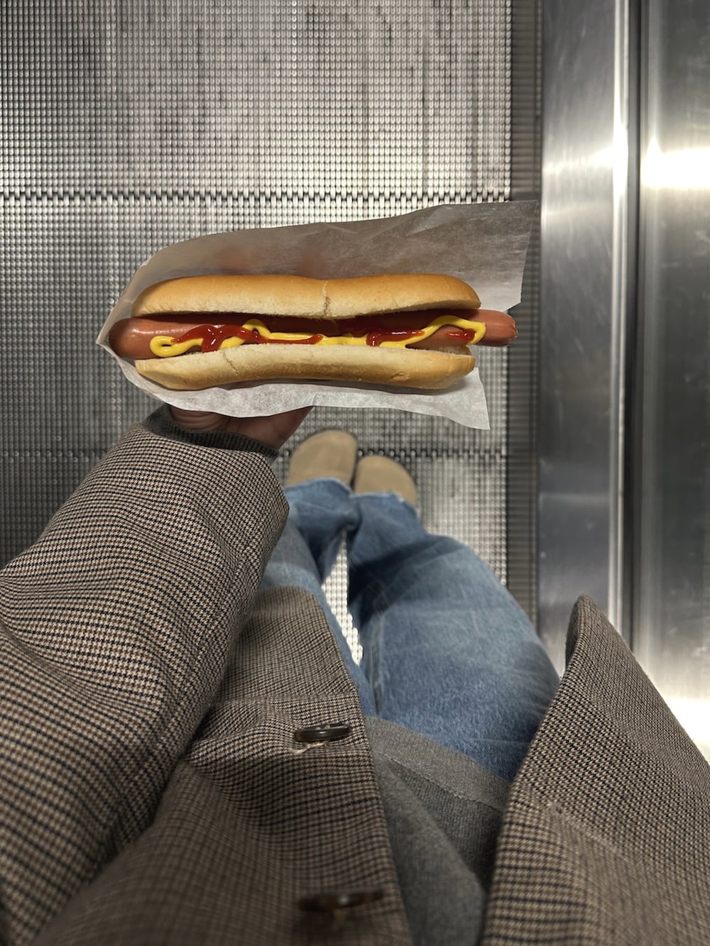 ブラウン系のテーラードジャケット、ブルー系のデニムパンツ、ベージュ系のサンダルを着用したレディースの春コーディネートの4枚目の写真