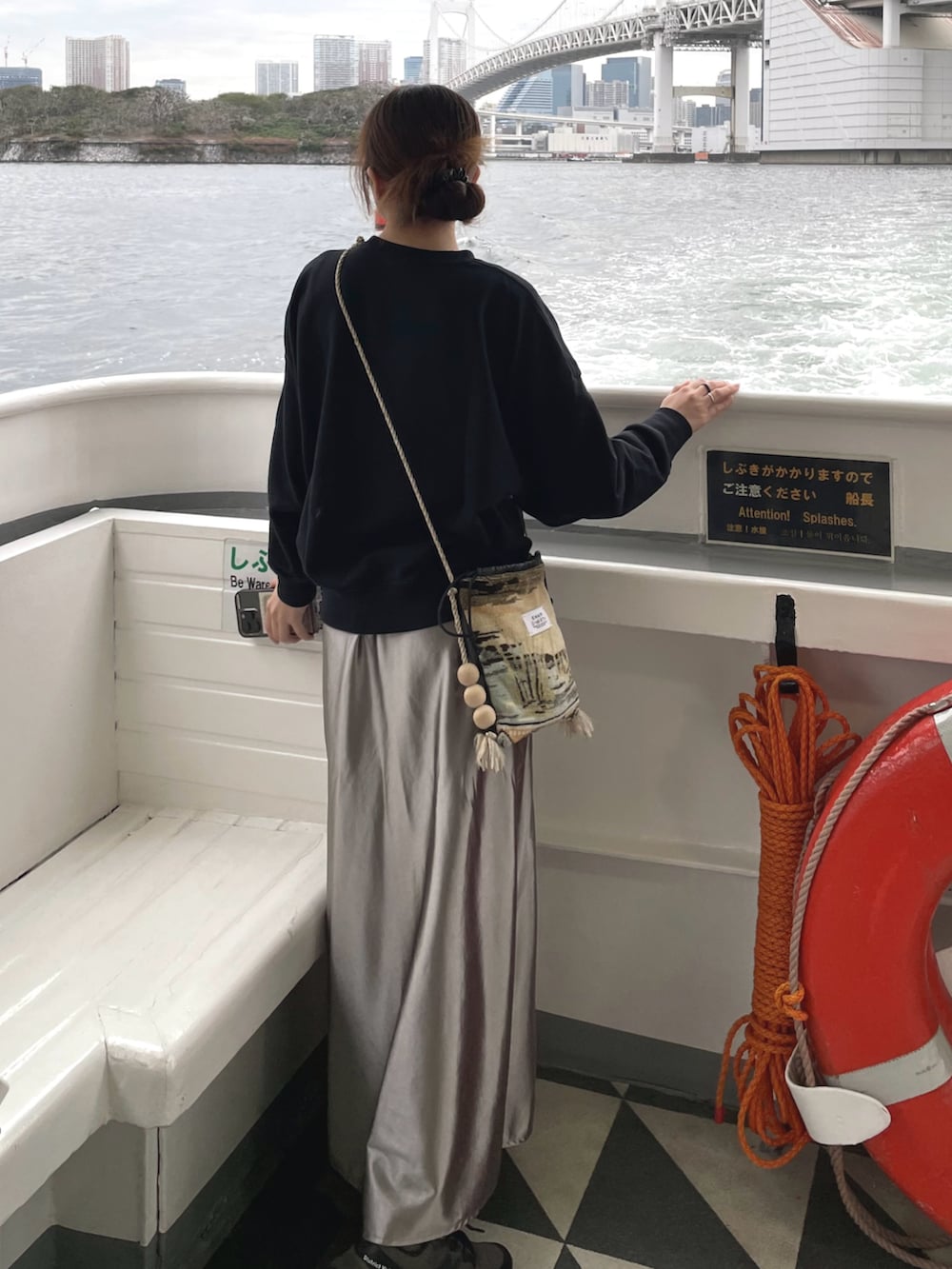 ブラック系のニット/セーター、ベージュ系のショルダーバッグ、グレー系のスニーカーを着用したレディースの秋コーディネートの3枚目の写真