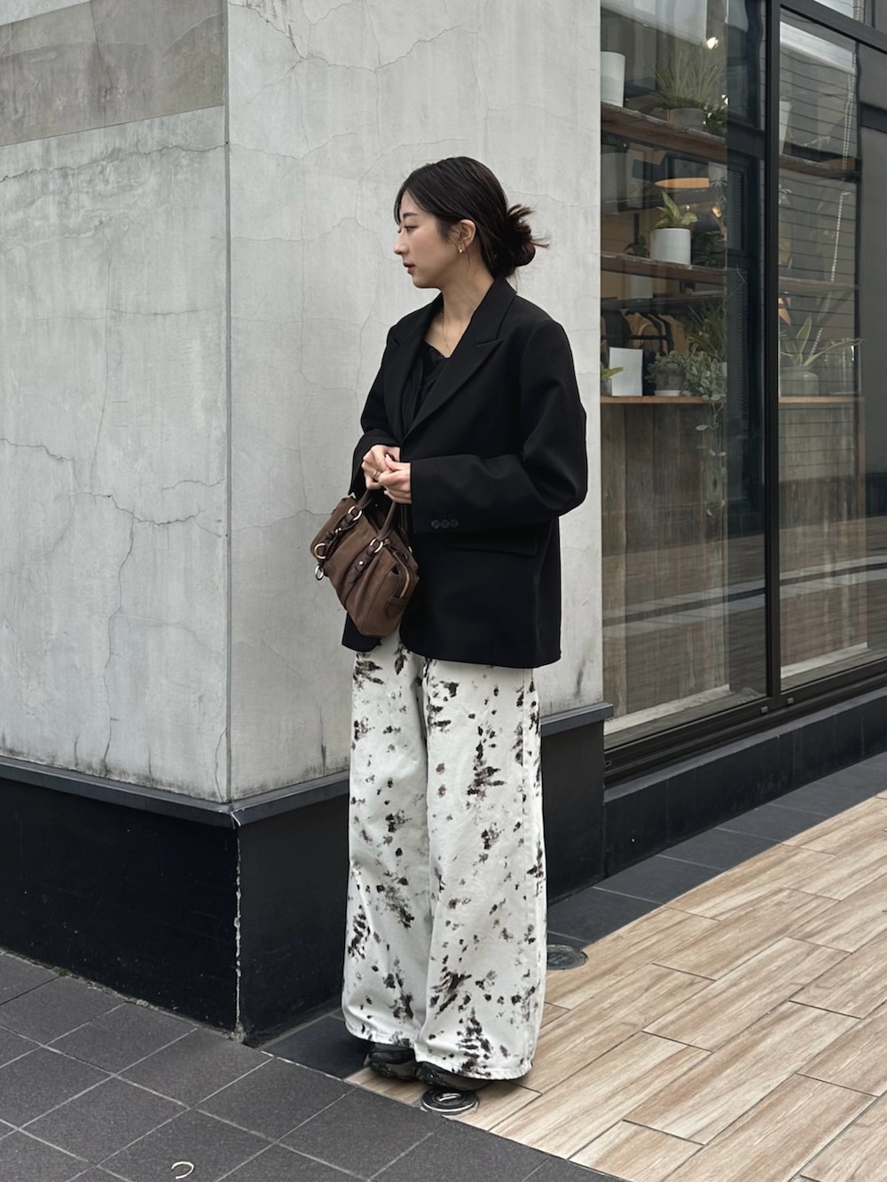 ホワイト系のデニムパンツ、ブラック系のテーラードジャケット、ブラウン系のトートバッグを着用したレディースの秋コーディネートの3枚目の写真