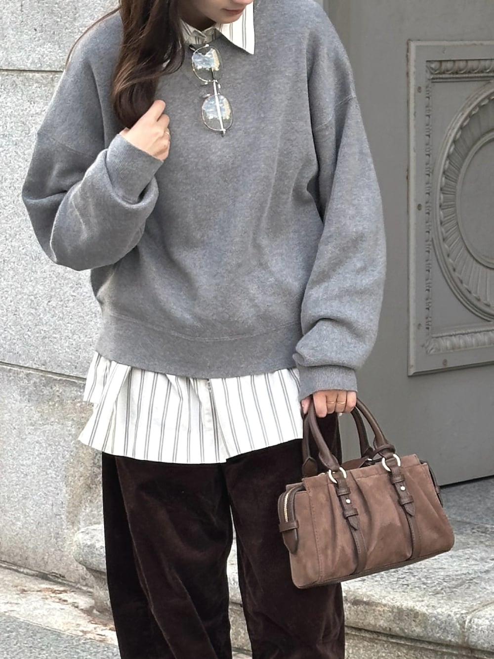 グレー系のニット/セーター、ホワイト系のシャツ/ブラウス、ブラウン系のその他パンツを着用したレディースの秋コーディネートの2枚目の写真