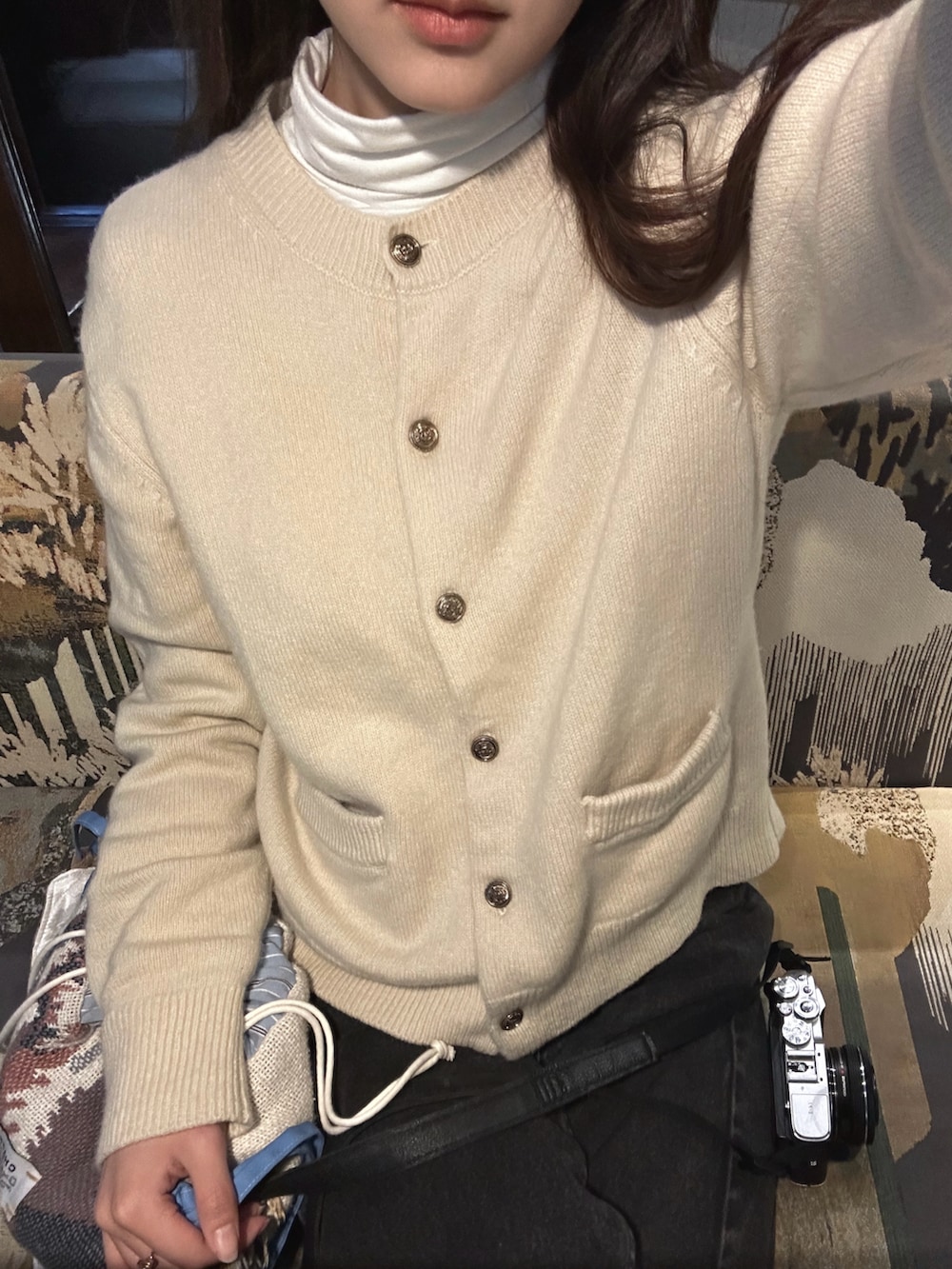 ブラック系のローファー、ホワイト系のニット/セーター、ブラック系のデニムパンツを着用したレディースの春コーディネートの2枚目の写真