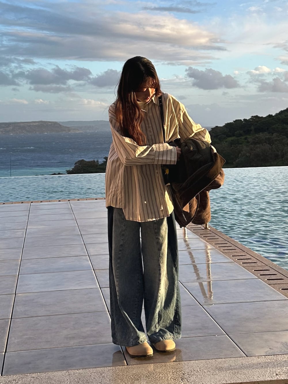 ホワイト系のシャツ/ブラウス、ブルー系のデニムパンツ、ベージュ系のサンダルを着用したレディースの冬コーディネートの2枚目の写真