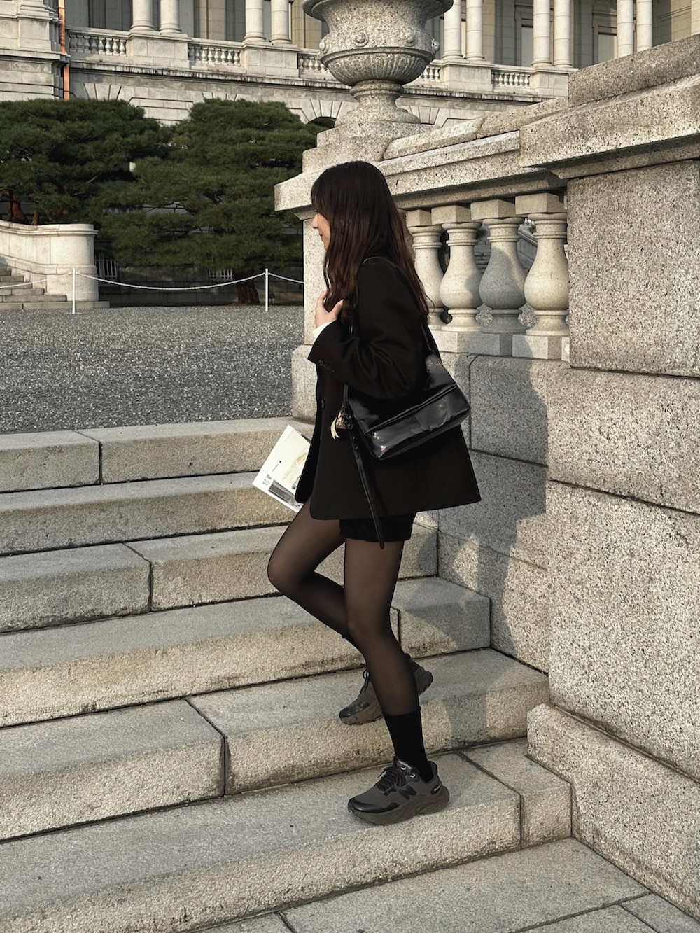 ホワイト系のニット/セーター、ブラック系のテーラードジャケット、ブラック系のその他パンツを着用したレディースの秋コーディネートの3枚目の写真