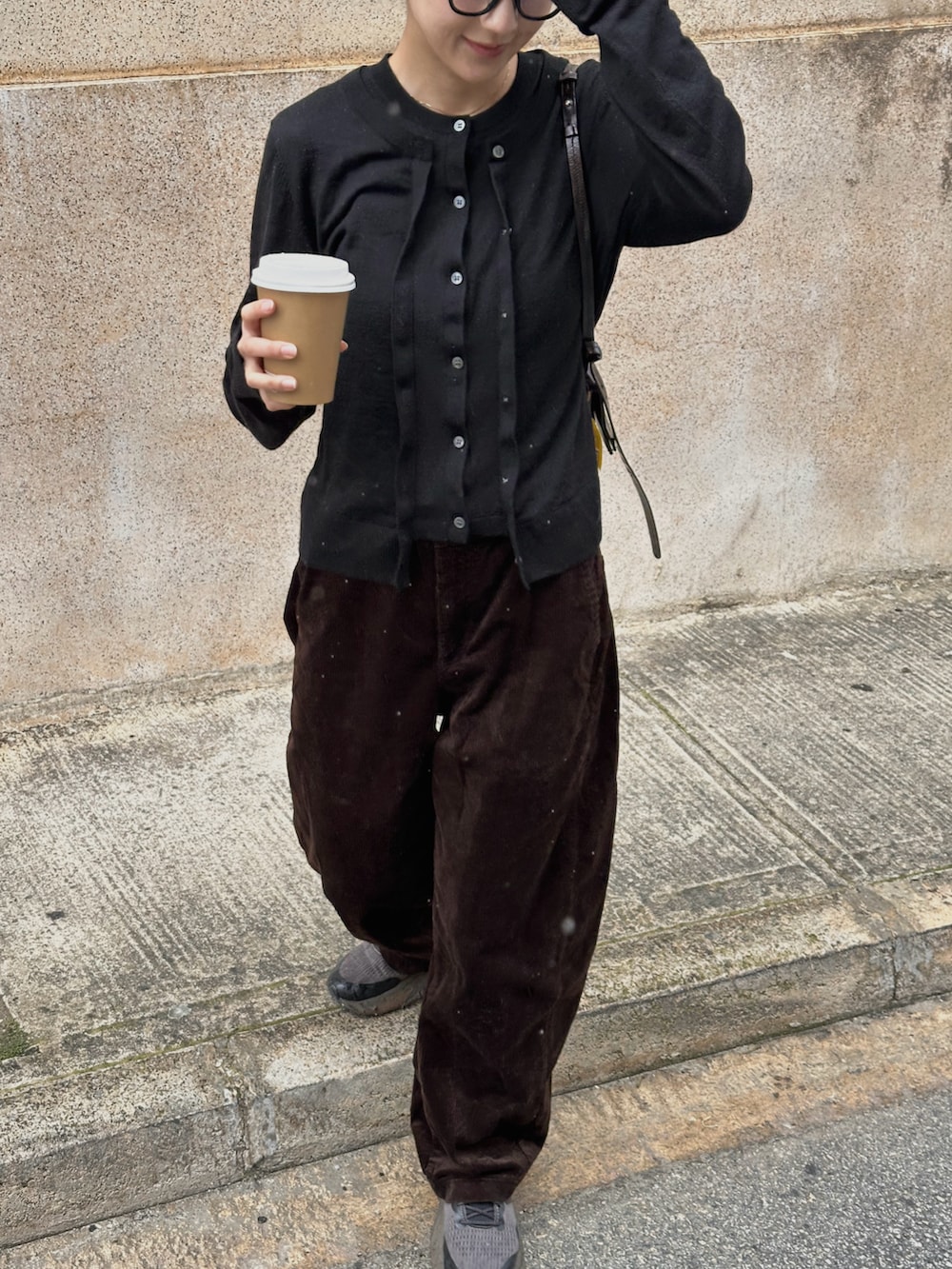 ブラック系のカーディガン/ボレロ、ブラウン系のその他パンツ、ブラック系のハンドバッグを着用したレディースの春コーディネートの2枚目の写真