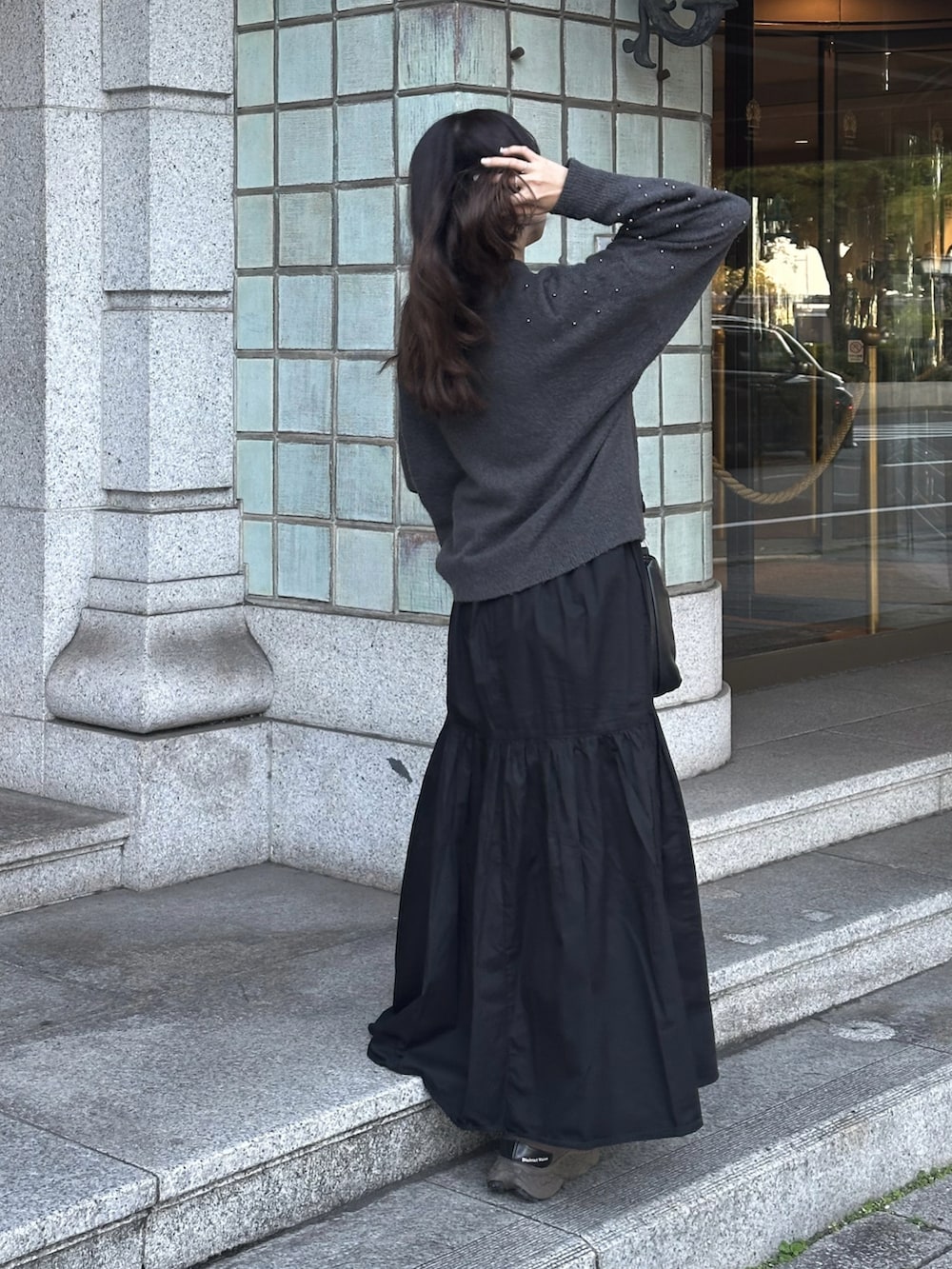 ブラック系のハンドバッグ、グレー系のニット/セーター、ブラック系のワンピースを着用したレディースの秋コーディネートの3枚目の写真