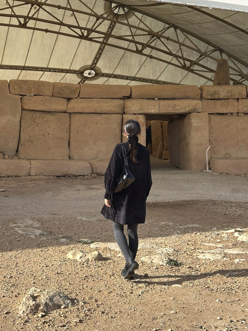 ブラック系のワンピース、ブラック系のハンドバッグ、ブラック系のローファーを着用したレディースの冬コーディネートの5枚目の写真