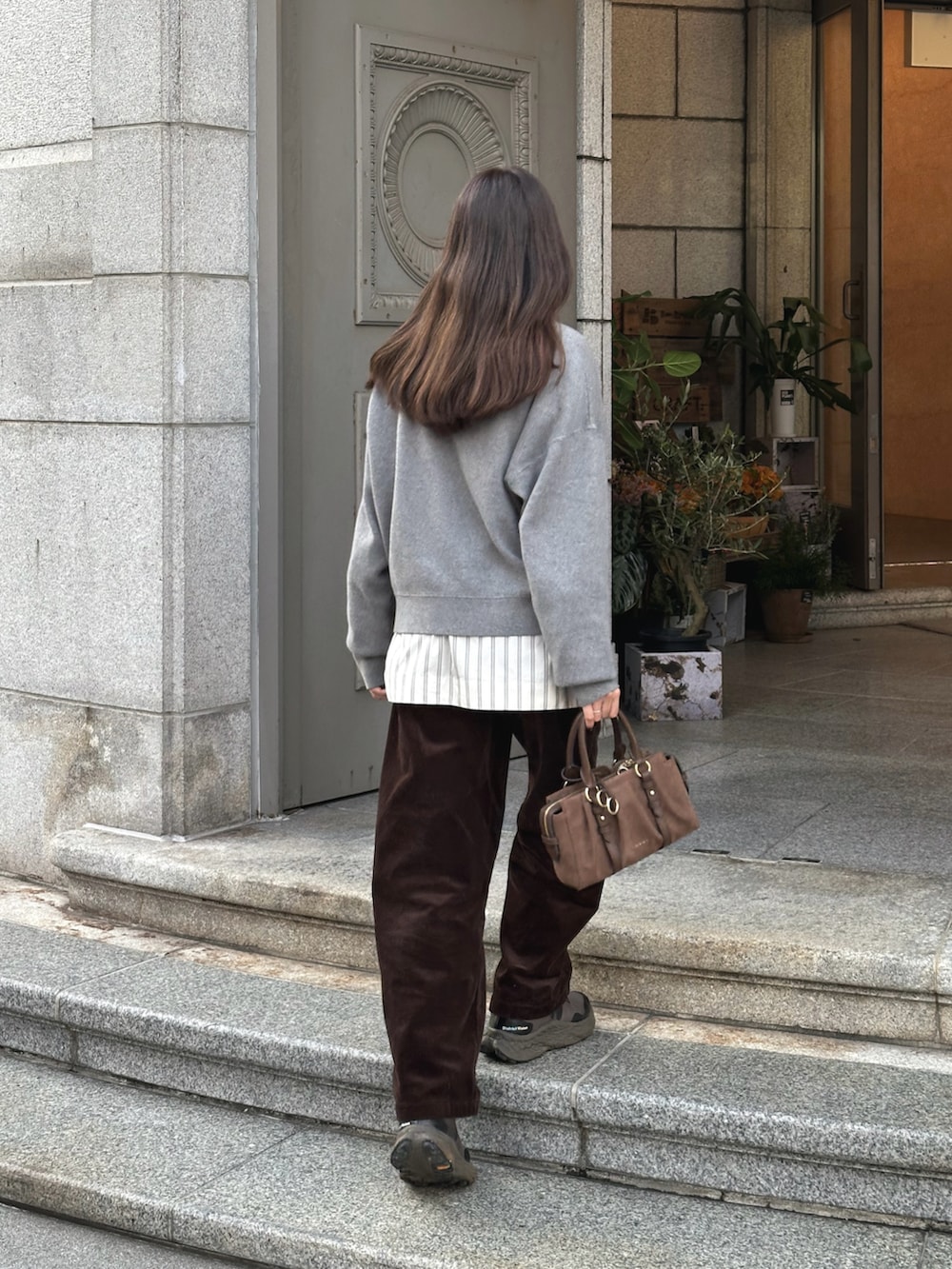 グレー系のニット/セーター、ホワイト系のシャツ/ブラウス、ブラウン系のその他パンツを着用したレディースの秋コーディネートの4枚目の写真