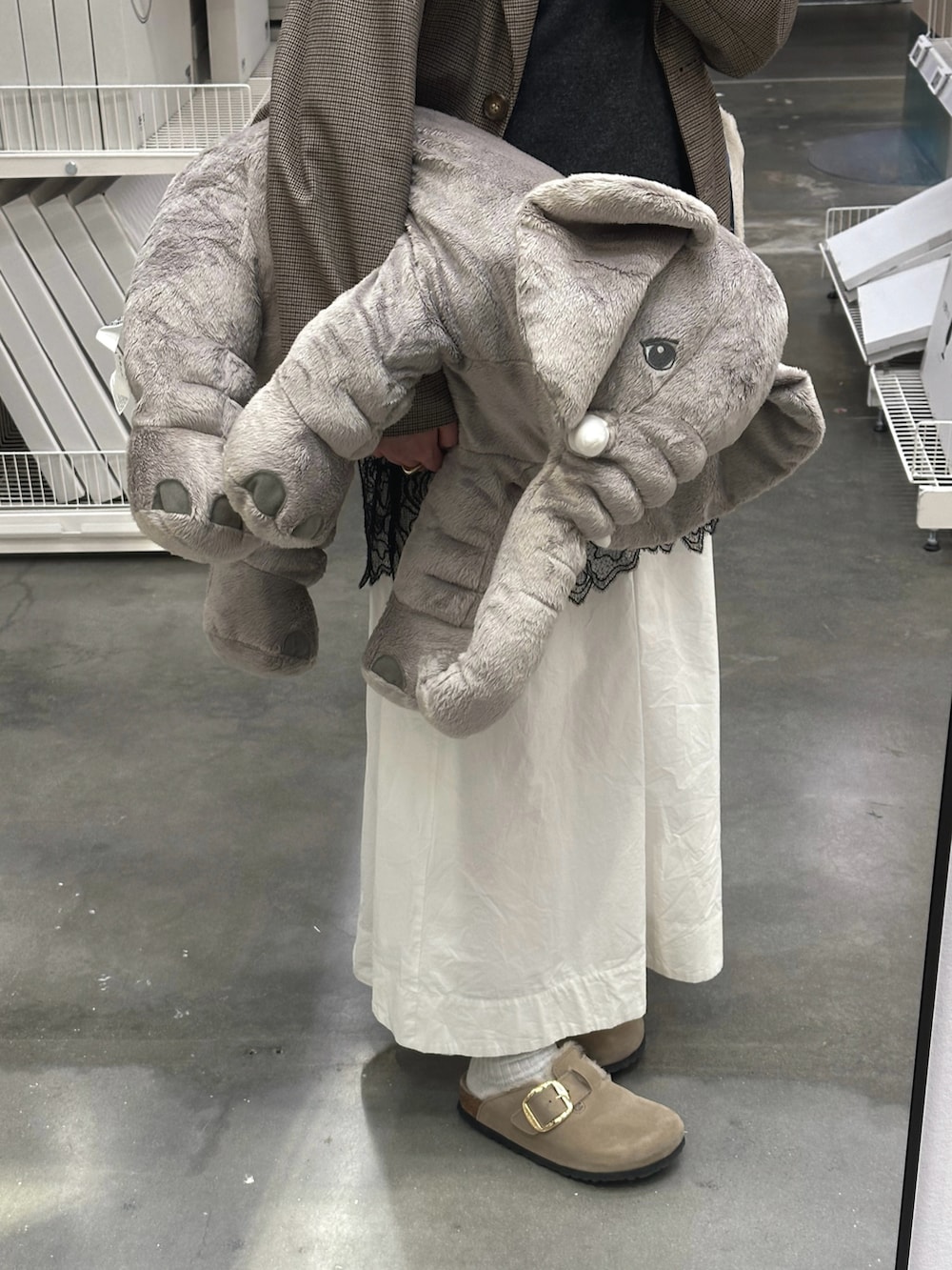 グレー系のニット/セーター、ホワイト系のワンピース、ベージュ系のサンダルを着用したレディースの春コーディネートの4枚目の写真