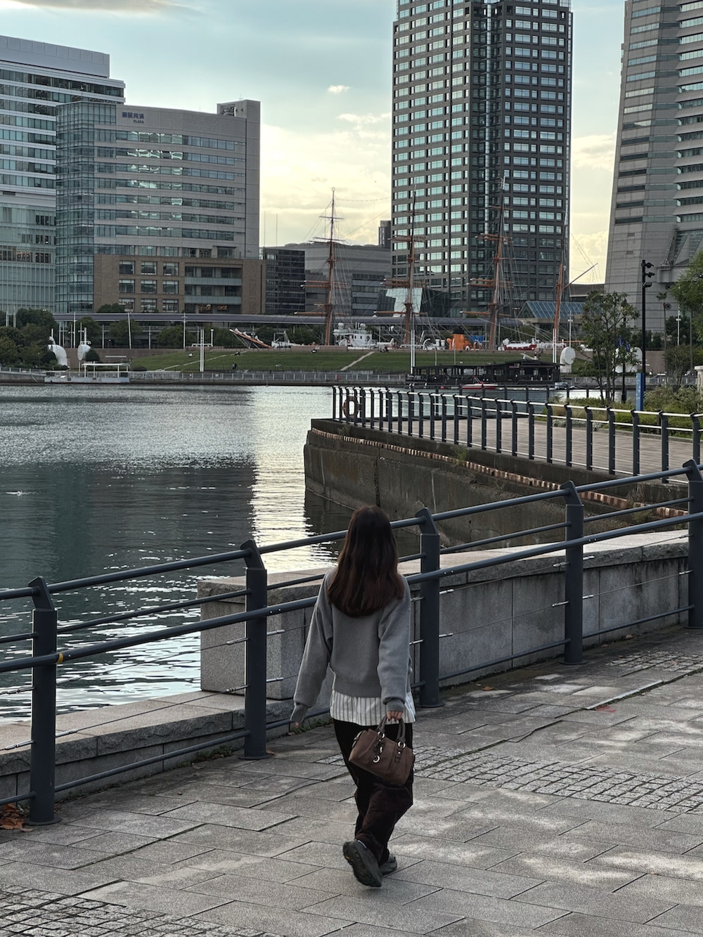 グレー系のニット/セーター、ホワイト系のシャツ/ブラウス、ブラウン系のその他パンツを着用したレディースの秋コーディネートの5枚目の写真