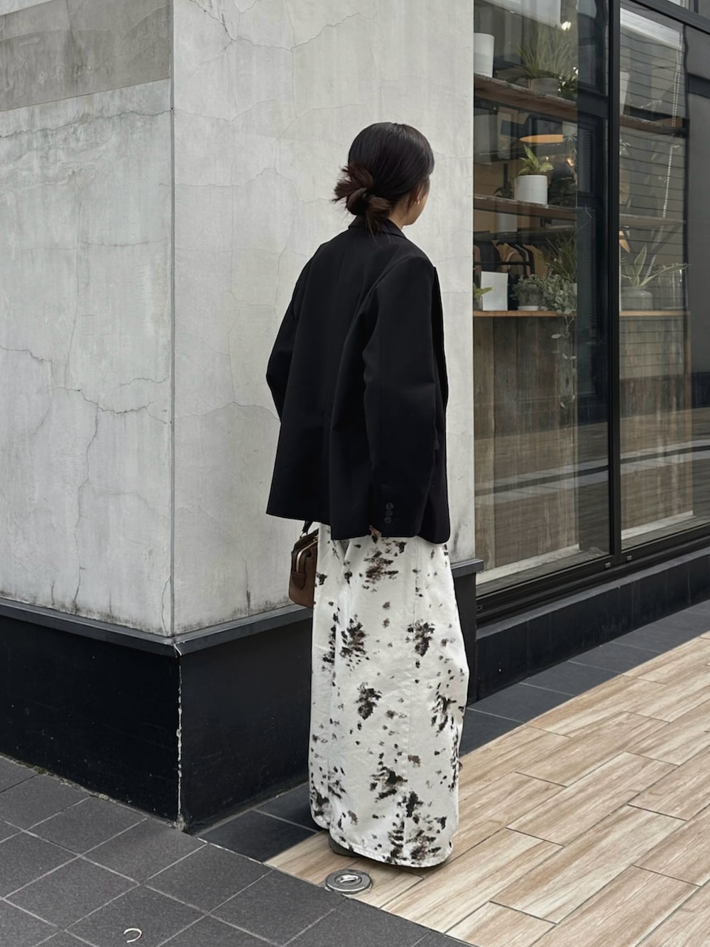 ホワイト系のデニムパンツ、ブラック系のテーラードジャケット、ブラウン系のトートバッグを着用したレディースの秋コーディネートの4枚目の写真