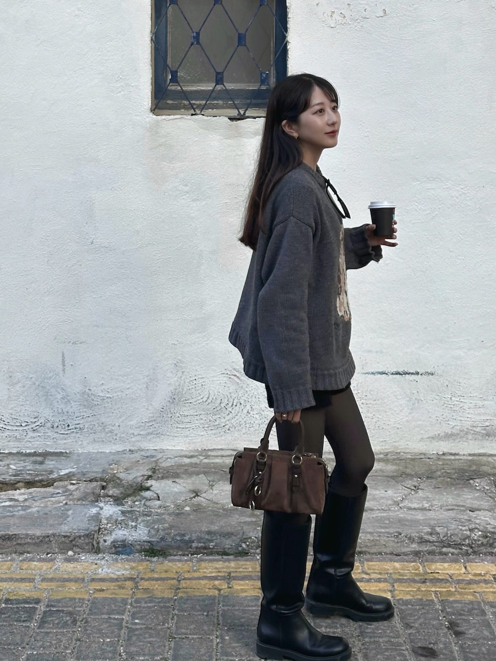 ブラウン系のトートバッグ、グレー系のニット/セーター、ブラック系のその他パンツを着用したレディースの春コーディネートの4枚目の写真