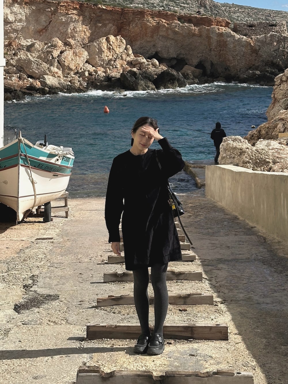 ブラック系のワンピース、ブラック系のハンドバッグ、ブラック系のローファーを着用したレディースの冬コーディネートの3枚目の写真