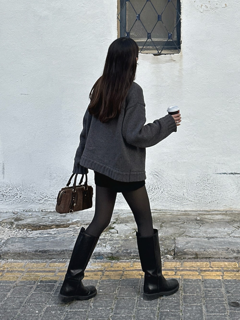ブラウン系のトートバッグ、グレー系のニット/セーター、ブラック系のその他パンツを着用したレディースの春コーディネートの3枚目の写真