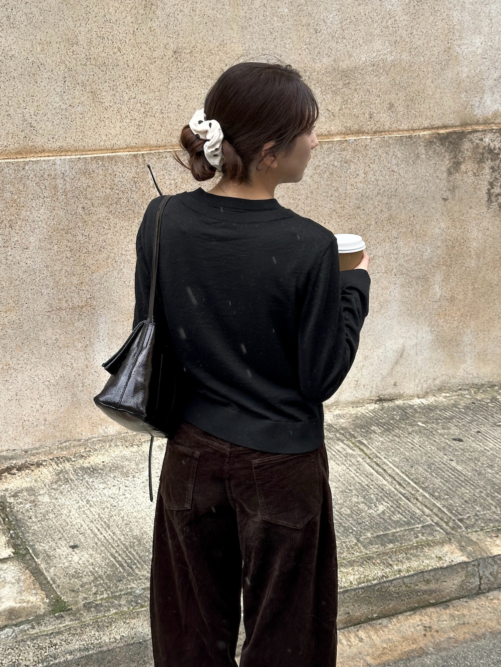 ブラック系のカーディガン/ボレロ、ブラウン系のその他パンツ、ブラック系のハンドバッグを着用したレディースの春コーディネートの3枚目の写真