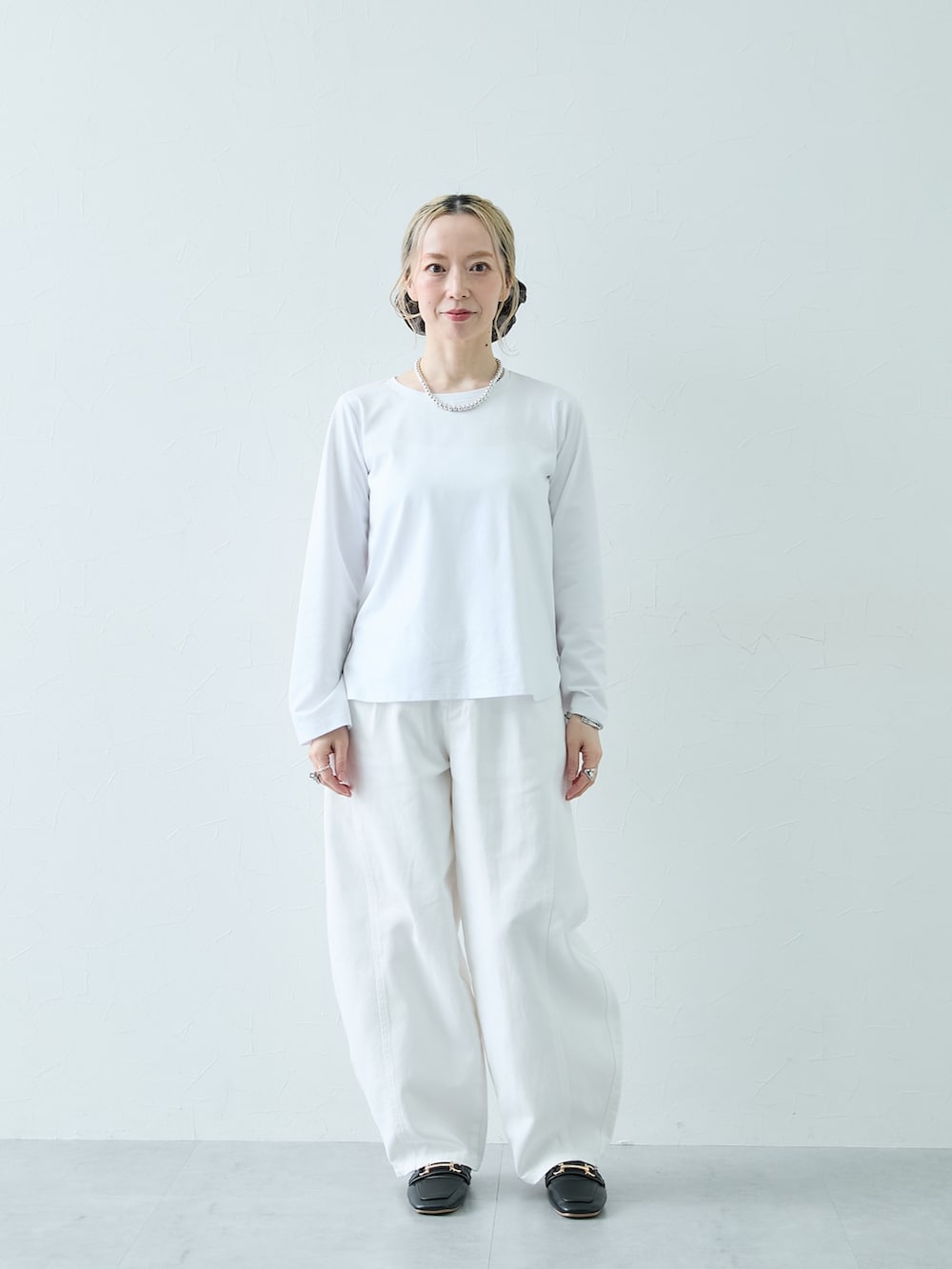 ホワイト系のTシャツ/カットソー、ホワイト系のパンツを着用したレディースの秋コーディネートの2枚目の写真