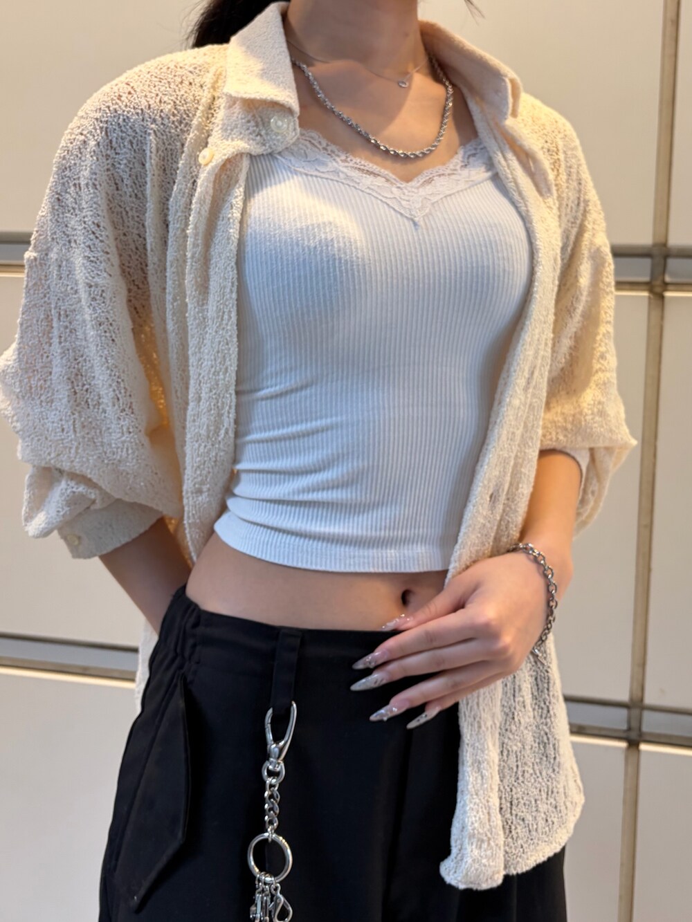 ブラック系のスラックス、ホワイト系のシャツ/ブラウス、シルバー系のネックレスを着用したレディースの春コーディネートの5枚目の写真