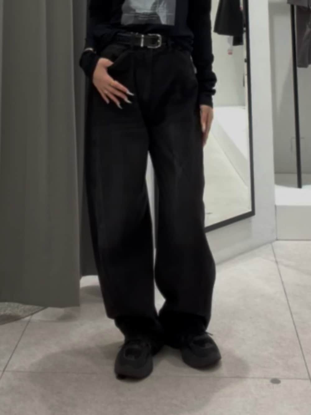 ブラック系のデニムパンツ、ブラック系のTシャツ/カットソー、ブラック系のベルトを着用したレディースの秋コーディネートの5枚目の写真