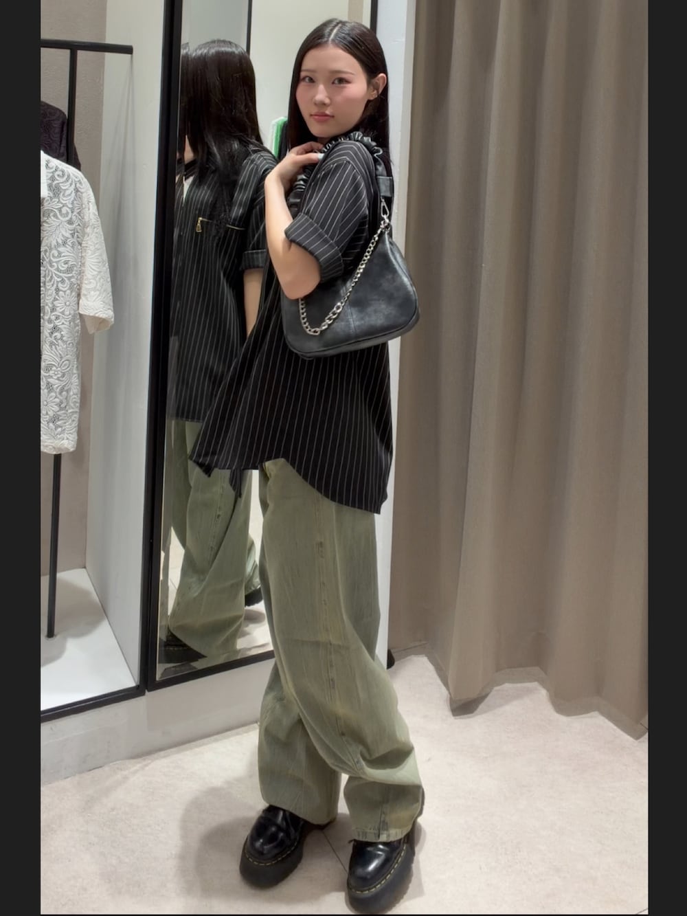ブラック系のシャツ/ブラウス、グリーン系のデニムパンツ、ブラック系のショルダーバッグを着用したレディースの春コーディネートの5枚目の写真