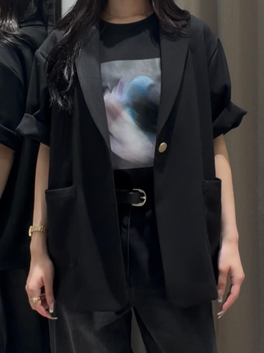 ブラック系のTシャツ/カットソー、ブラック系のテーラードジャケット、ブラック系のデニムパンツを着用したレディースの夏コーディネートの3枚目の写真