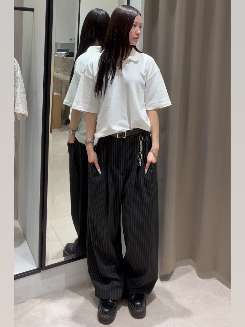 ブラック系のスラックス、ホワイト系のTシャツ/カットソー、ブラック系のキャップを着用したレディースの春コーディネートの3枚目の写真