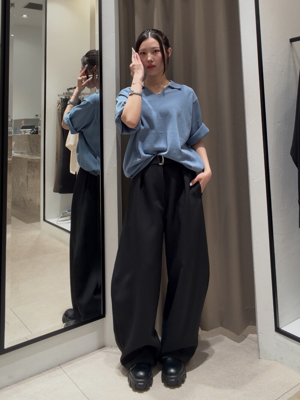 ブラック系のその他シューズ、ブラック系のスラックス、ブルー系のTシャツ/カットソーを着用したレディースの春コーディネートの4枚目の写真