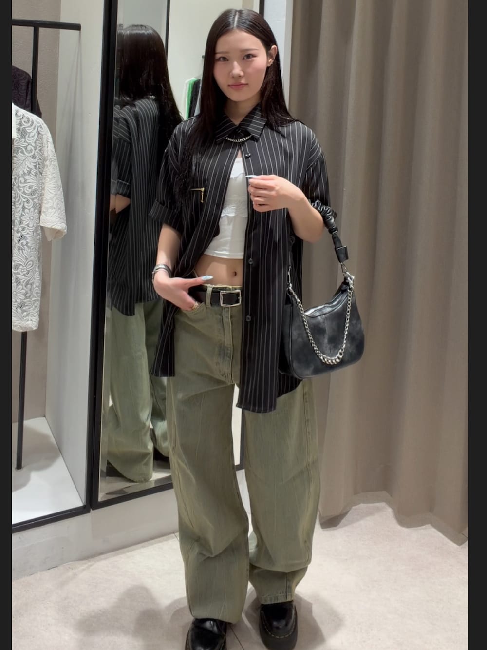 ブラック系のシャツ/ブラウス、グリーン系のデニムパンツ、ブラック系のショルダーバッグを着用したレディースの春コーディネートの2枚目の写真