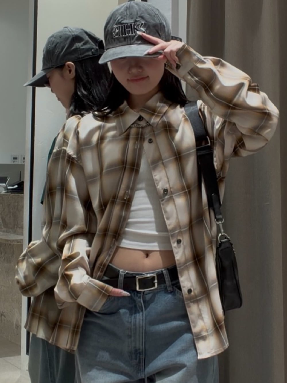 ブルー系のデニムパンツ、ホワイト系のシャツ/ブラウス、ブラック系のショルダーバッグを着用したレディースの春コーディネートの6枚目の写真