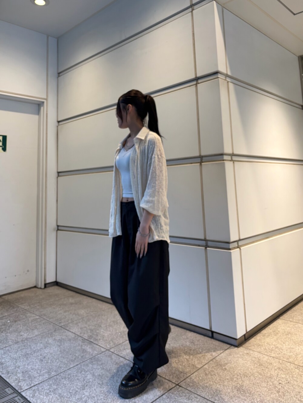 ブラック系のスラックス、ホワイト系のシャツ/ブラウス、シルバー系のネックレスを着用したレディースの春コーディネートの2枚目の写真
