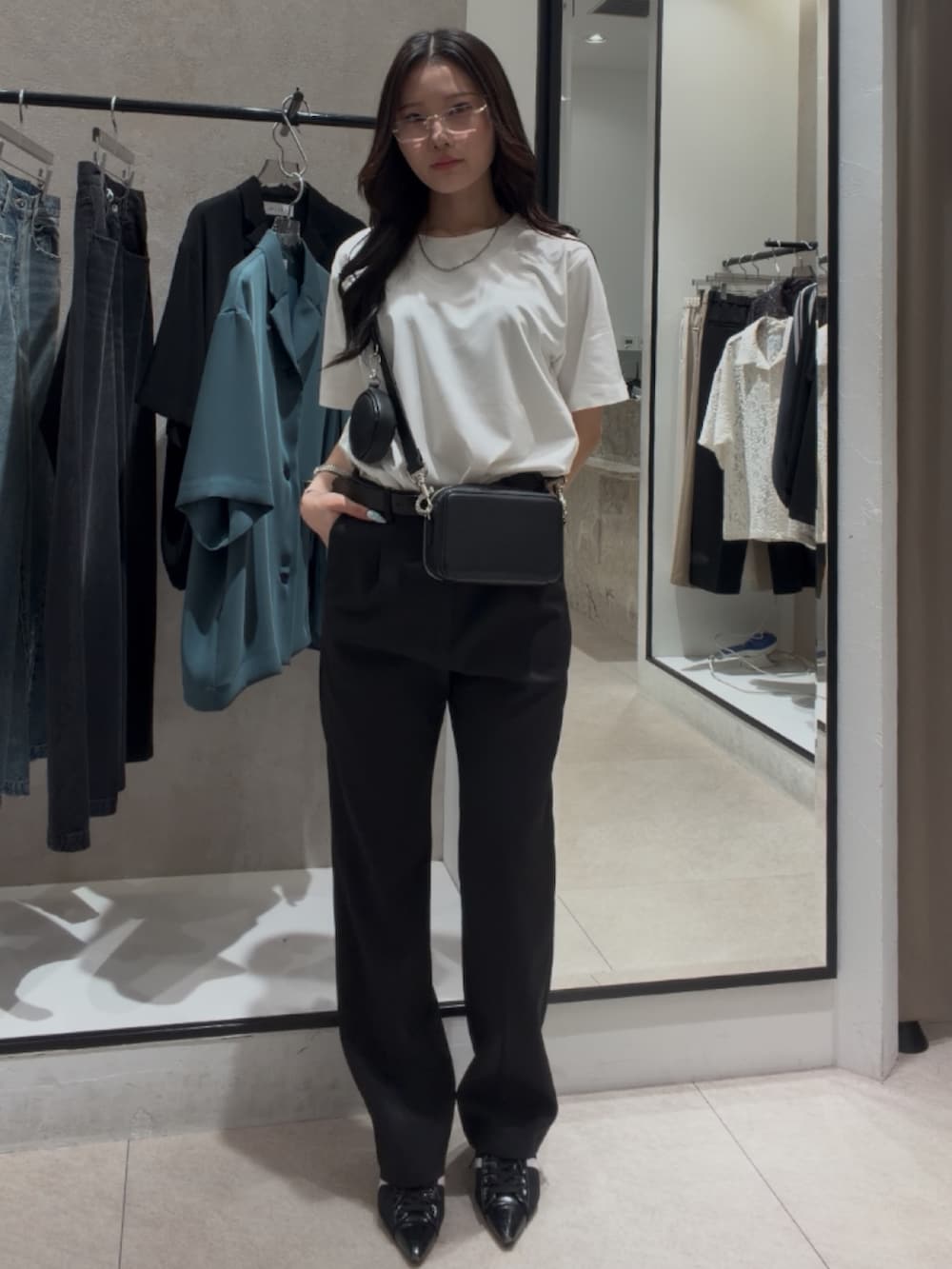 ブラック系のショルダーバッグ、ブラック系のスラックス、ホワイト系のTシャツ/カットソーを着用したレディースの春コーディネートの3枚目の写真