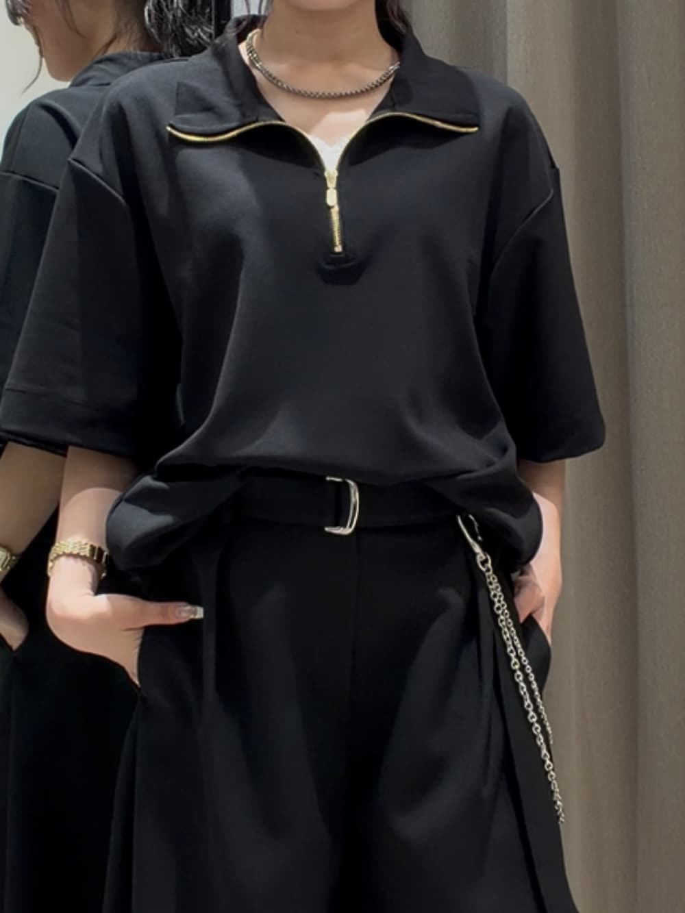 ブラック系のTシャツ/カットソー、ブラック系のスラックス、シルバー系のネックレスを着用したレディースの夏コーディネートの3枚目の写真