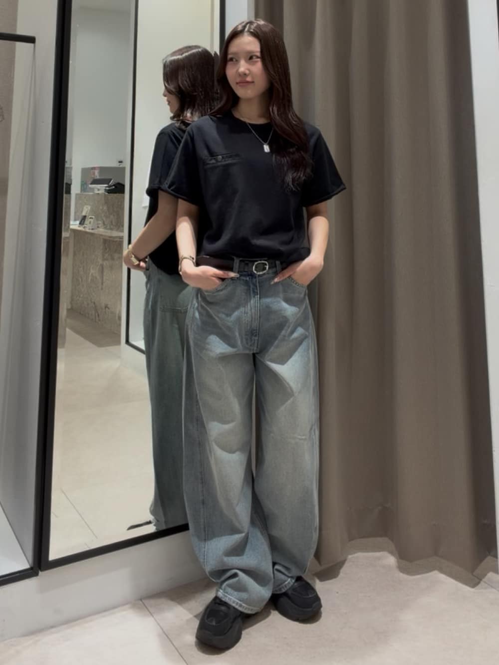 ブラック系のTシャツ/カットソー、ブルー系のデニムパンツ、ブラック系のベルトを着用したレディースの夏コーディネートの2枚目の写真