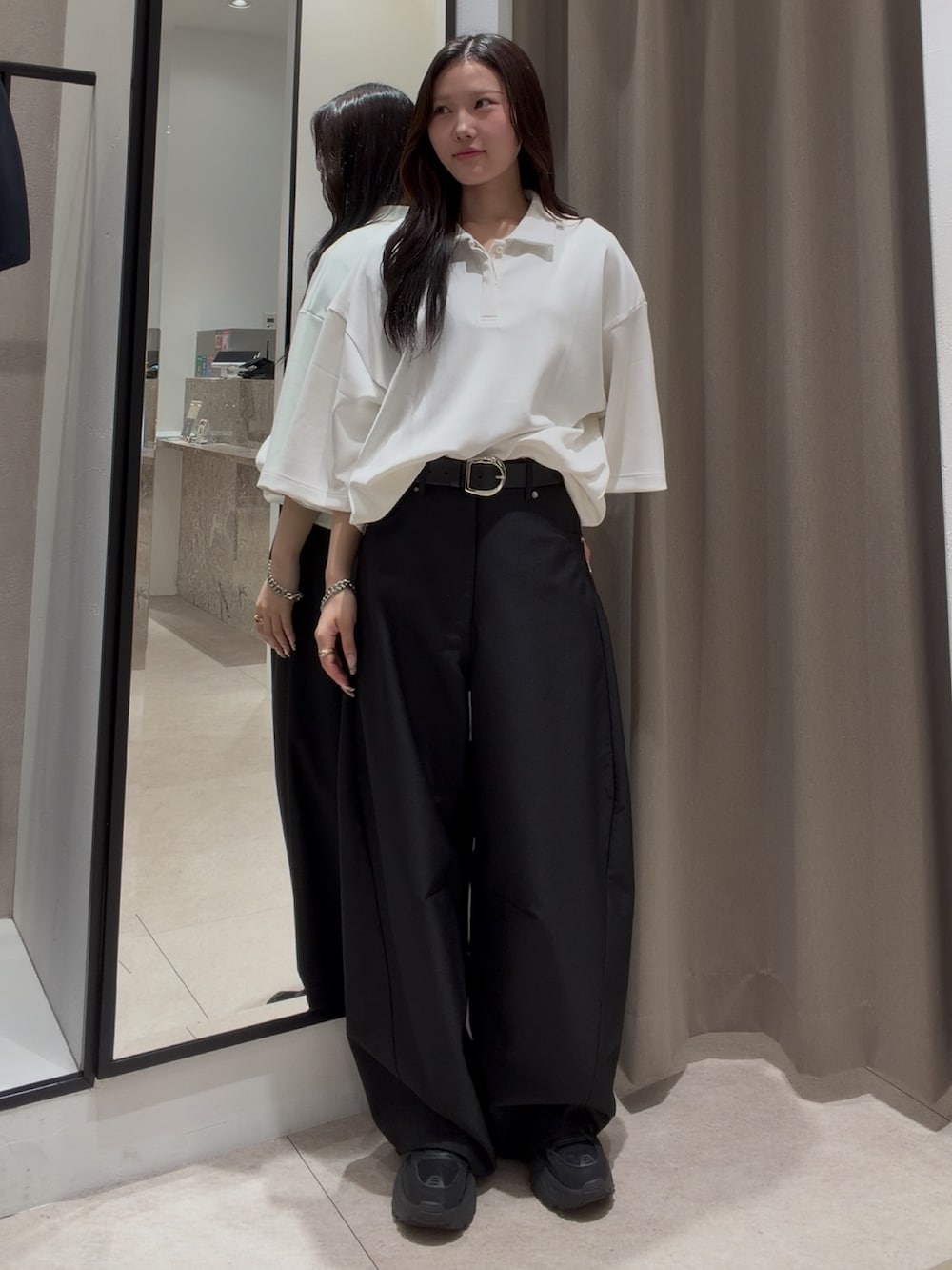ホワイト系のTシャツ/カットソー、ブラック系のスラックス、シルバー系のブレスレットを着用したレディースの夏コーディネートの2枚目の写真
