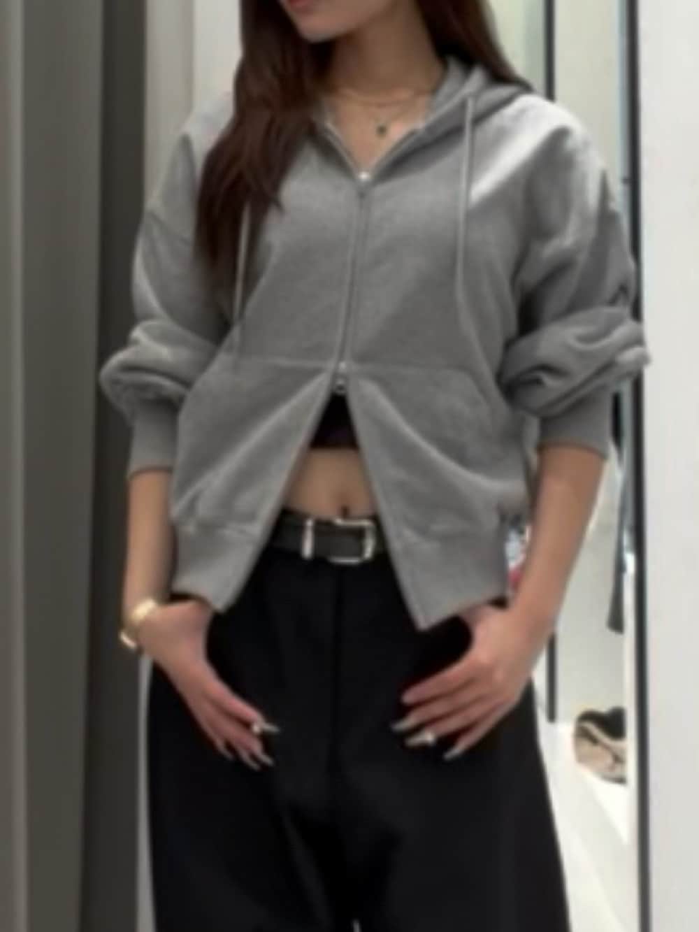 グレー系のパーカー、ブラック系のスラックス、ブラック系のその他シューズを着用したレディースの秋コーディネートの3枚目の写真