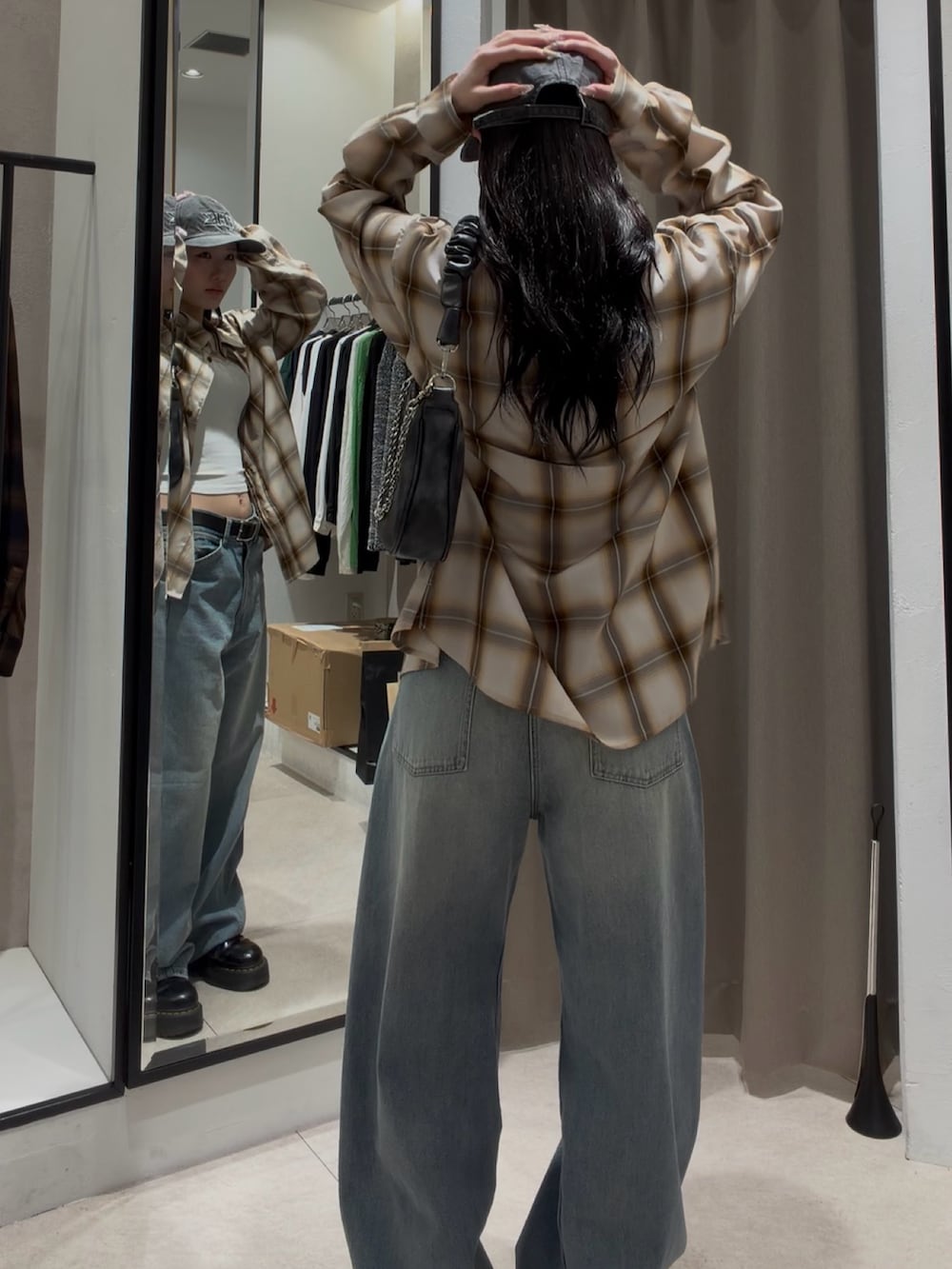 ブルー系のデニムパンツ、ホワイト系のシャツ/ブラウス、ブラック系のショルダーバッグを着用したレディースの春コーディネートの4枚目の写真