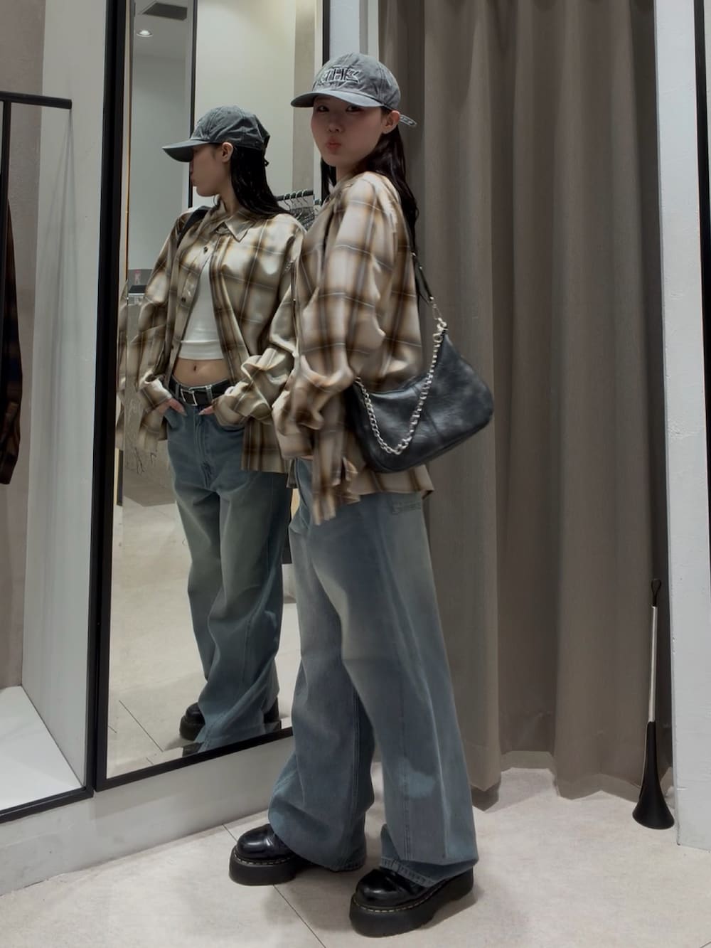 ブルー系のデニムパンツ、ホワイト系のシャツ/ブラウス、ブラック系のショルダーバッグを着用したレディースの春コーディネートの3枚目の写真