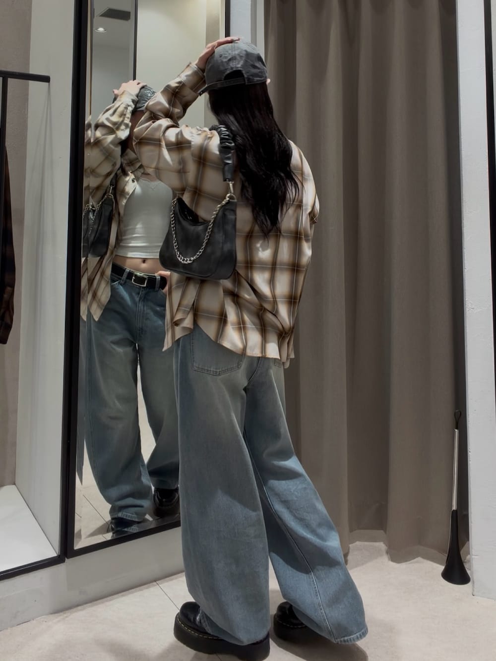 ブルー系のデニムパンツ、ホワイト系のシャツ/ブラウス、ブラック系のショルダーバッグを着用したレディースの春コーディネートの2枚目の写真