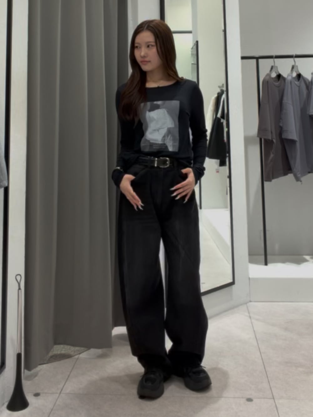 ブラック系のデニムパンツ、ブラック系のTシャツ/カットソー、ブラック系のベルトを着用したレディースの秋コーディネートの3枚目の写真