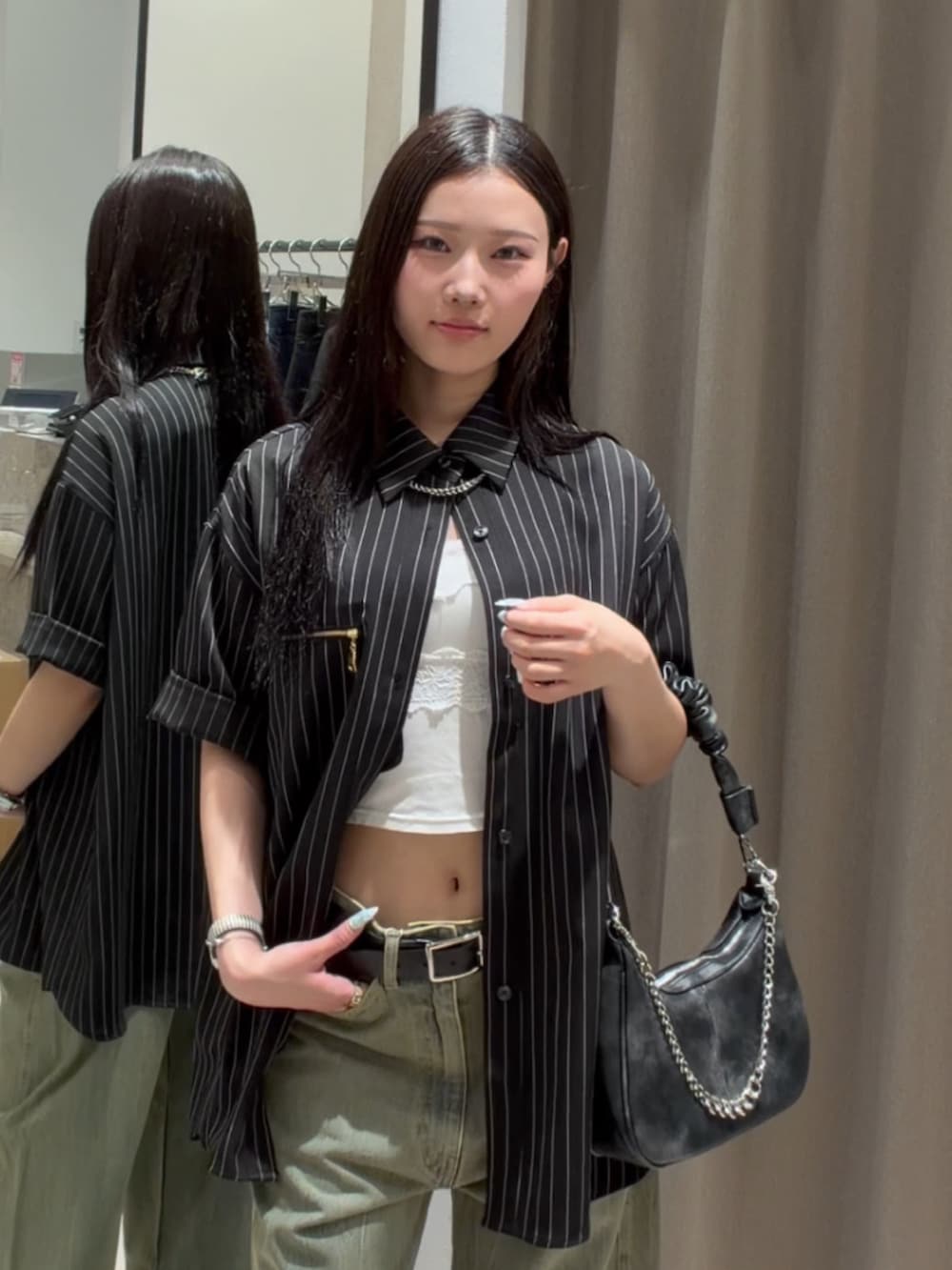 ブラック系のシャツ/ブラウス、グリーン系のデニムパンツ、ブラック系のショルダーバッグを着用したレディースの春コーディネートの6枚目の写真