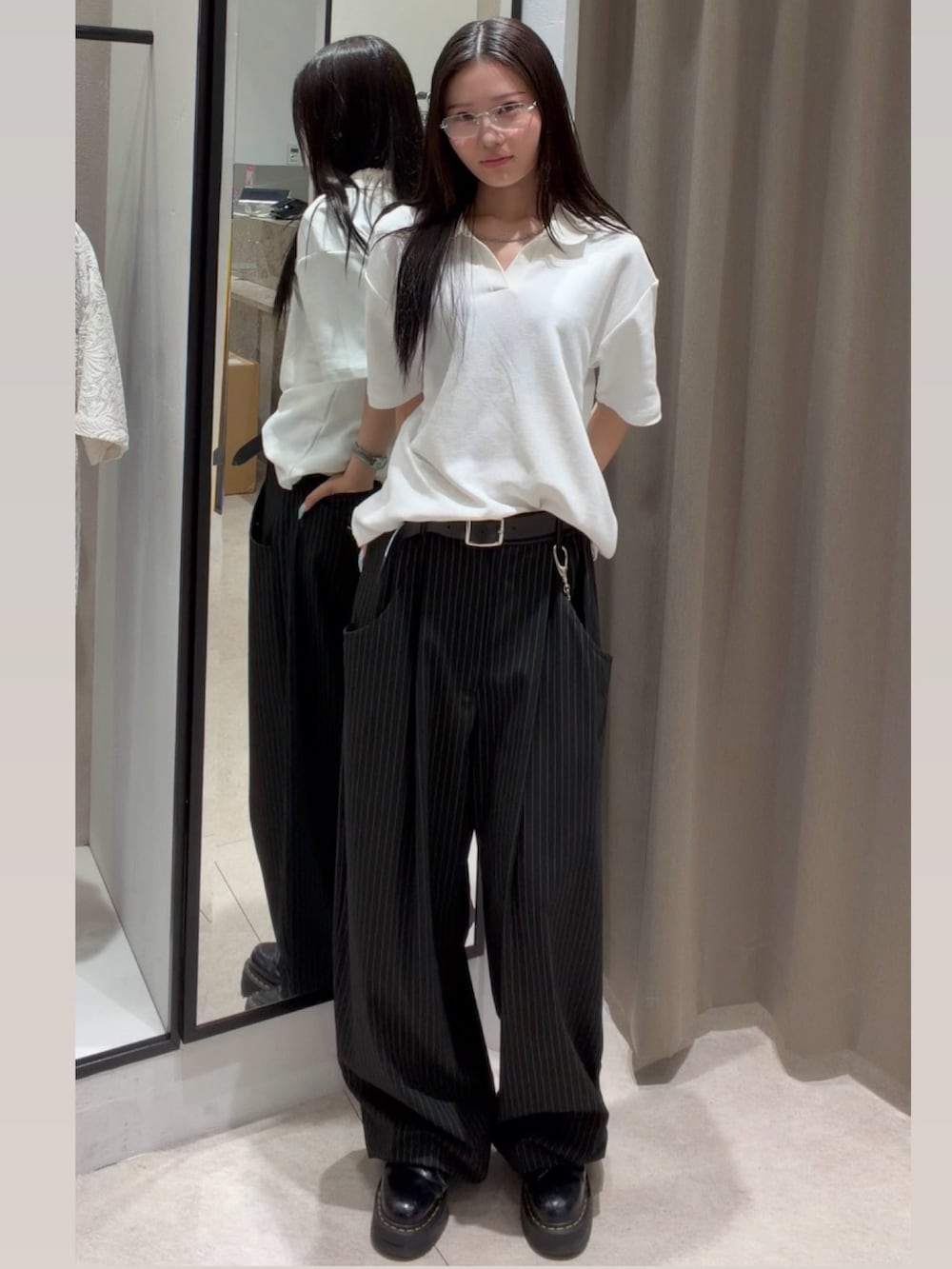 ブラック系のスラックス、ホワイト系のTシャツ/カットソー、ブラック系のキャップを着用したレディースの春コーディネートの2枚目の写真