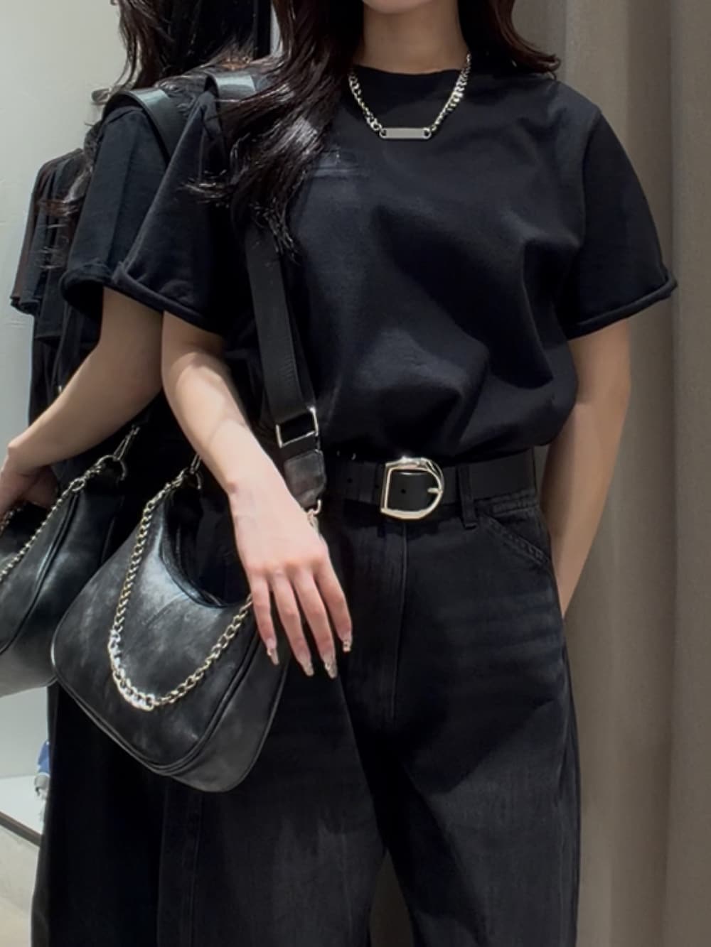 ブラック系のデニムパンツ、ブラック系のショルダーバッグ、ブラック系のTシャツ/カットソーを着用したレディースの夏コーディネートの3枚目の写真