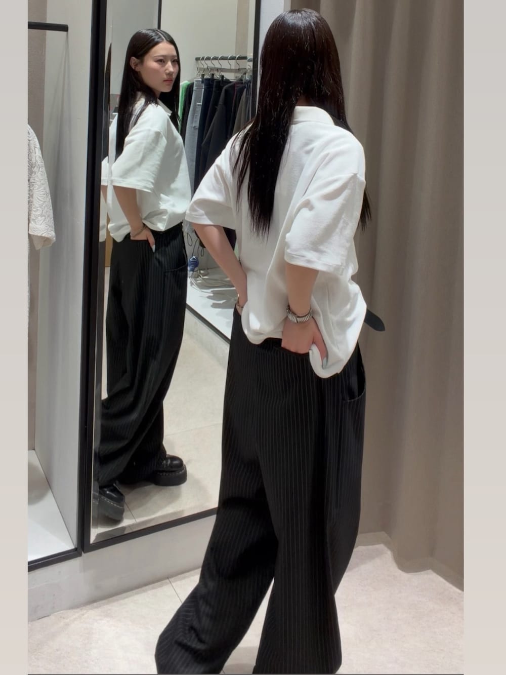 ブラック系のスラックス、ホワイト系のTシャツ/カットソー、ブラック系のキャップを着用したレディースの春コーディネートの5枚目の写真