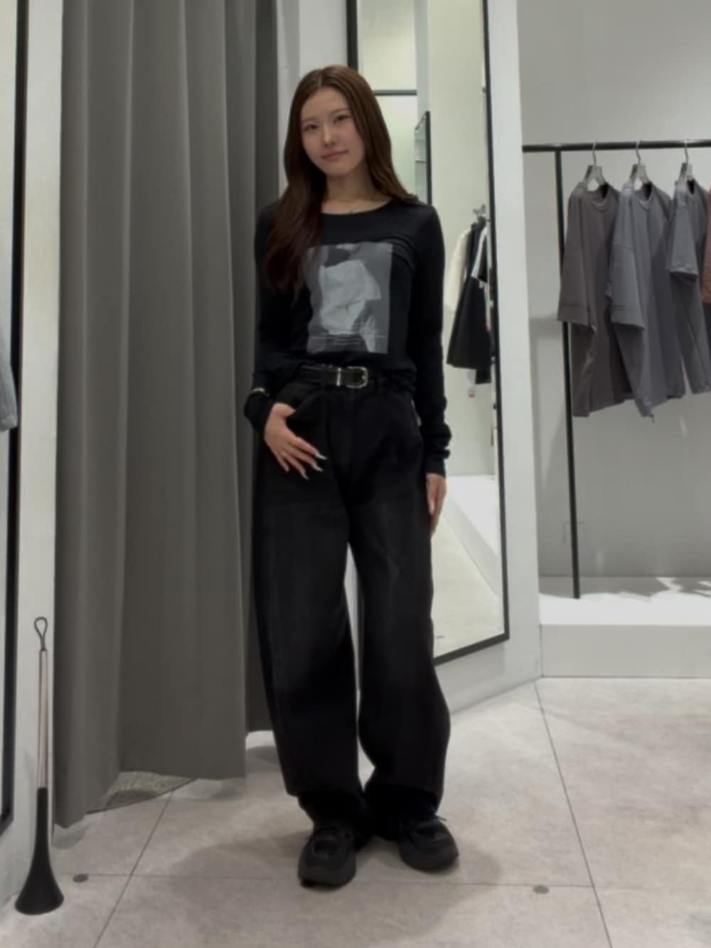 ブラック系のデニムパンツ、ブラック系のTシャツ/カットソー、ブラック系のベルトを着用したレディースの秋コーディネートの2枚目の写真