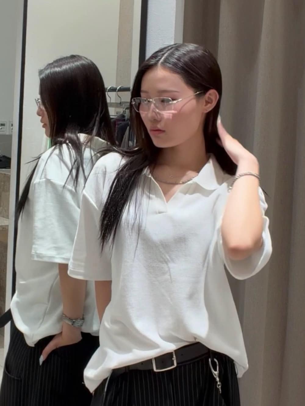 ブラック系のスラックス、ホワイト系のTシャツ/カットソー、ブラック系のキャップを着用したレディースの春コーディネートの7枚目の写真