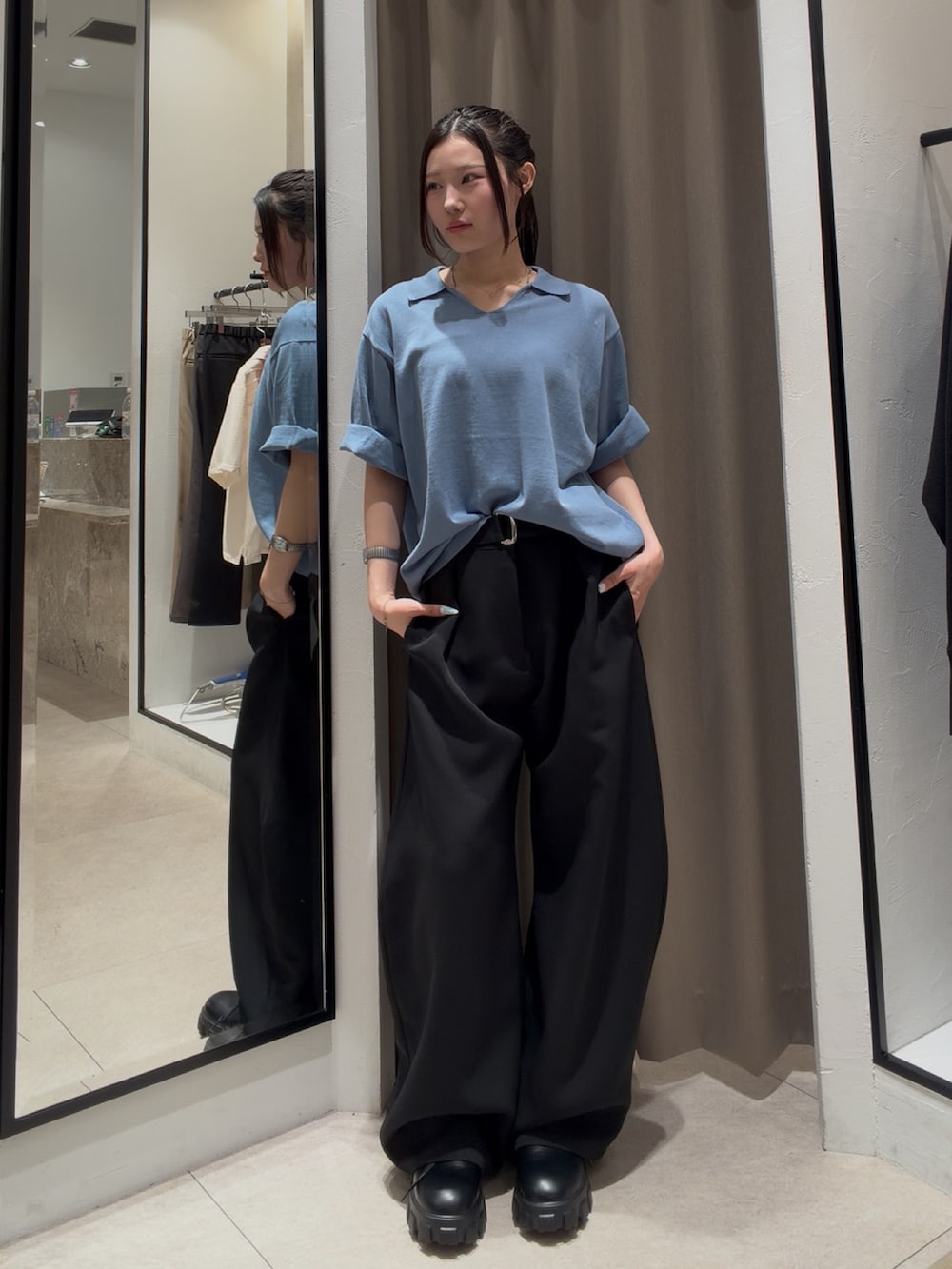 ブラック系のその他シューズ、ブラック系のスラックス、ブルー系のTシャツ/カットソーを着用したレディースの春コーディネートの2枚目の写真