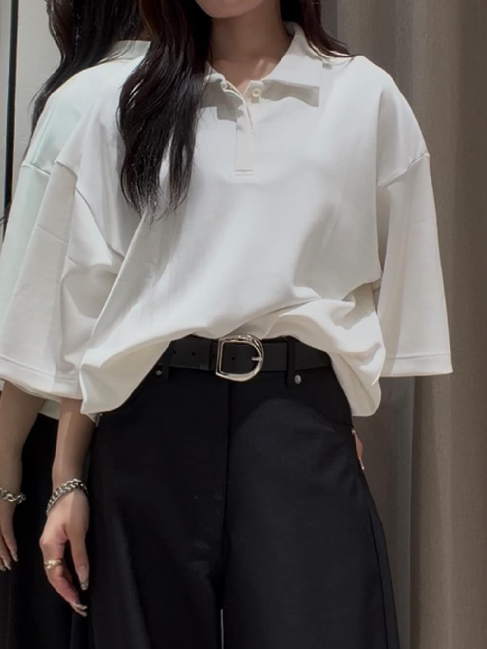 ホワイト系のTシャツ/カットソー、ブラック系のスラックス、シルバー系のブレスレットを着用したレディースの夏コーディネートの4枚目の写真