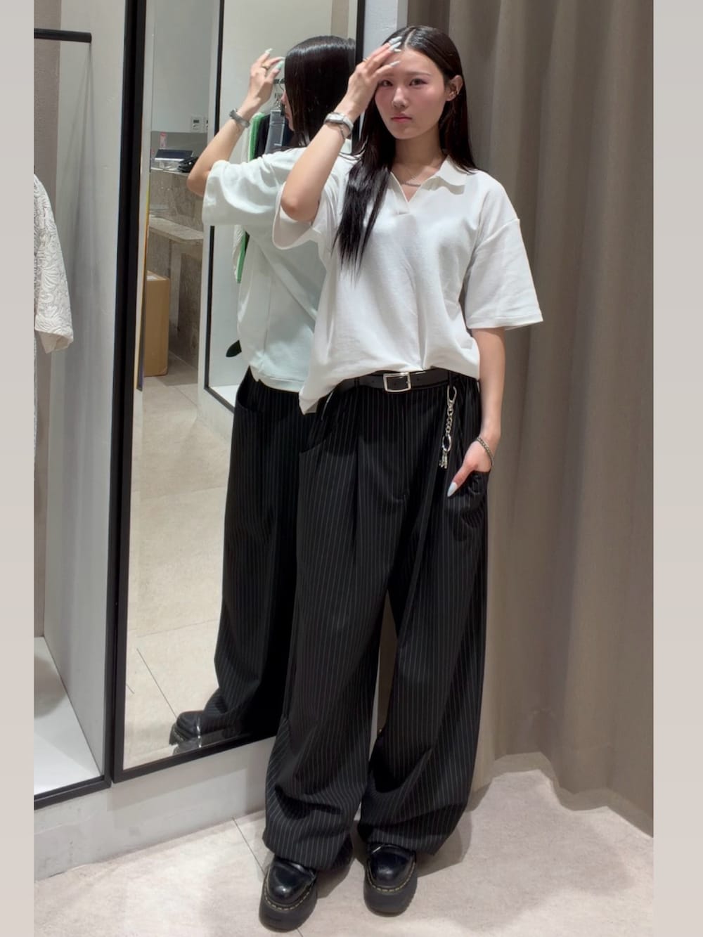 ブラック系のスラックス、ホワイト系のTシャツ/カットソー、ブラック系のキャップを着用したレディースの春コーディネートの4枚目の写真