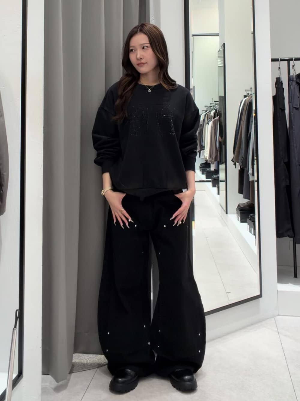 ブラック系のスウェット、ブラック系のデニムパンツ、ブラック系のその他シューズを着用したレディースの秋コーディネートの2枚目の写真