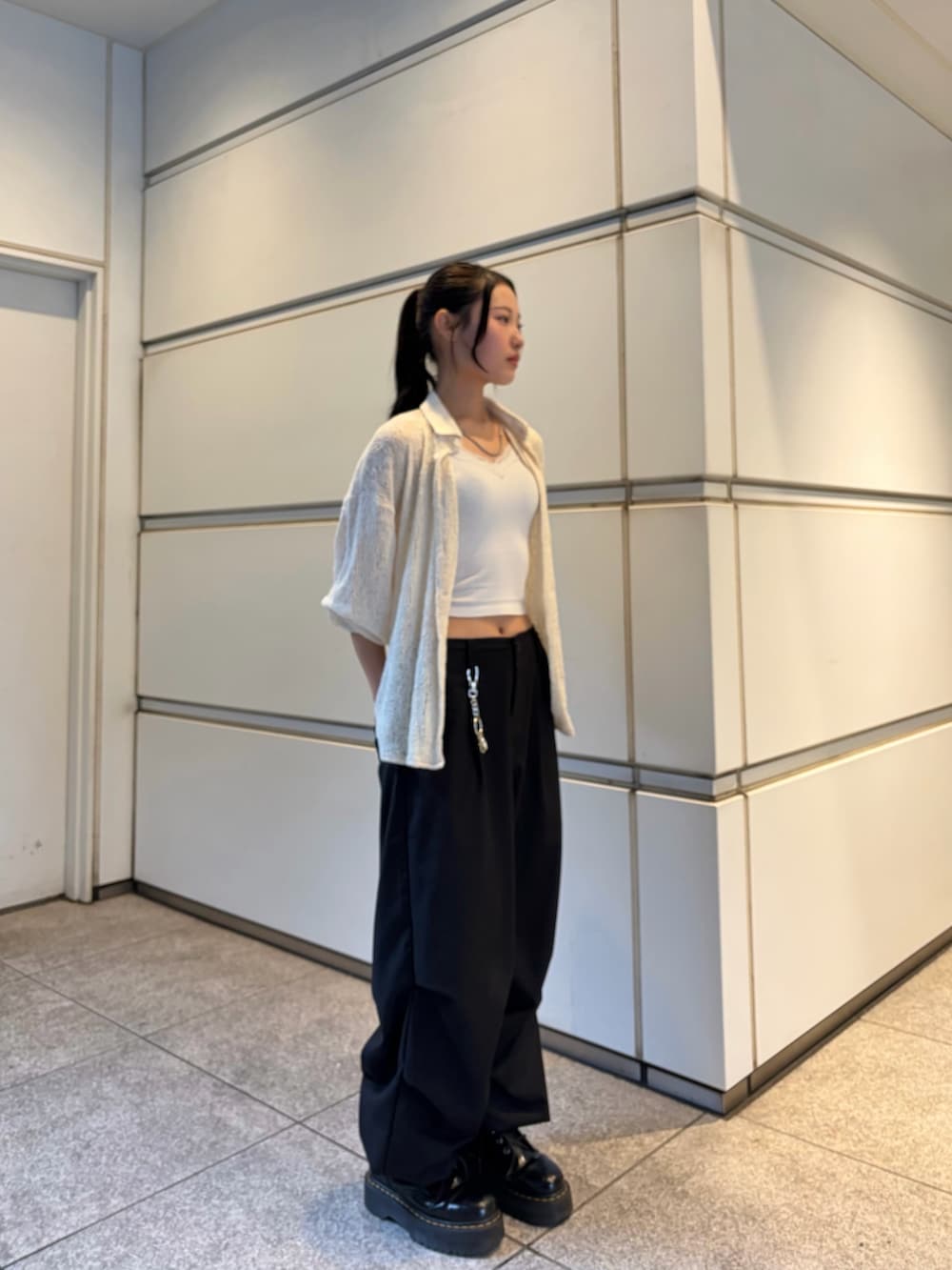 ブラック系のスラックス、ホワイト系のシャツ/ブラウス、シルバー系のネックレスを着用したレディースの春コーディネートの3枚目の写真